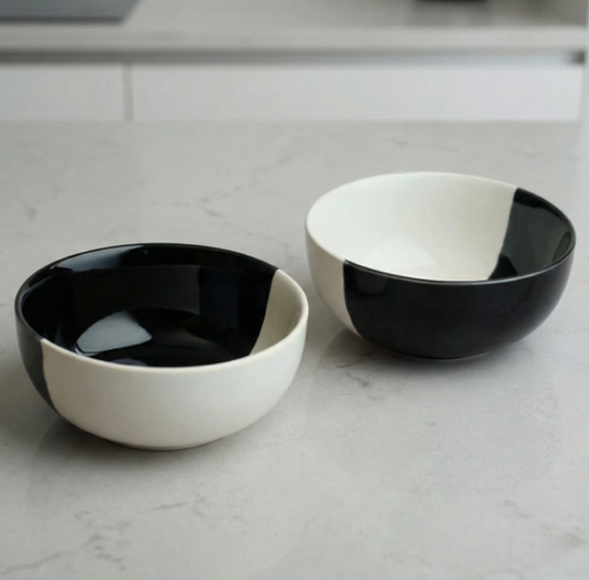 Two black and white ceramic bowls on a light gray surface.