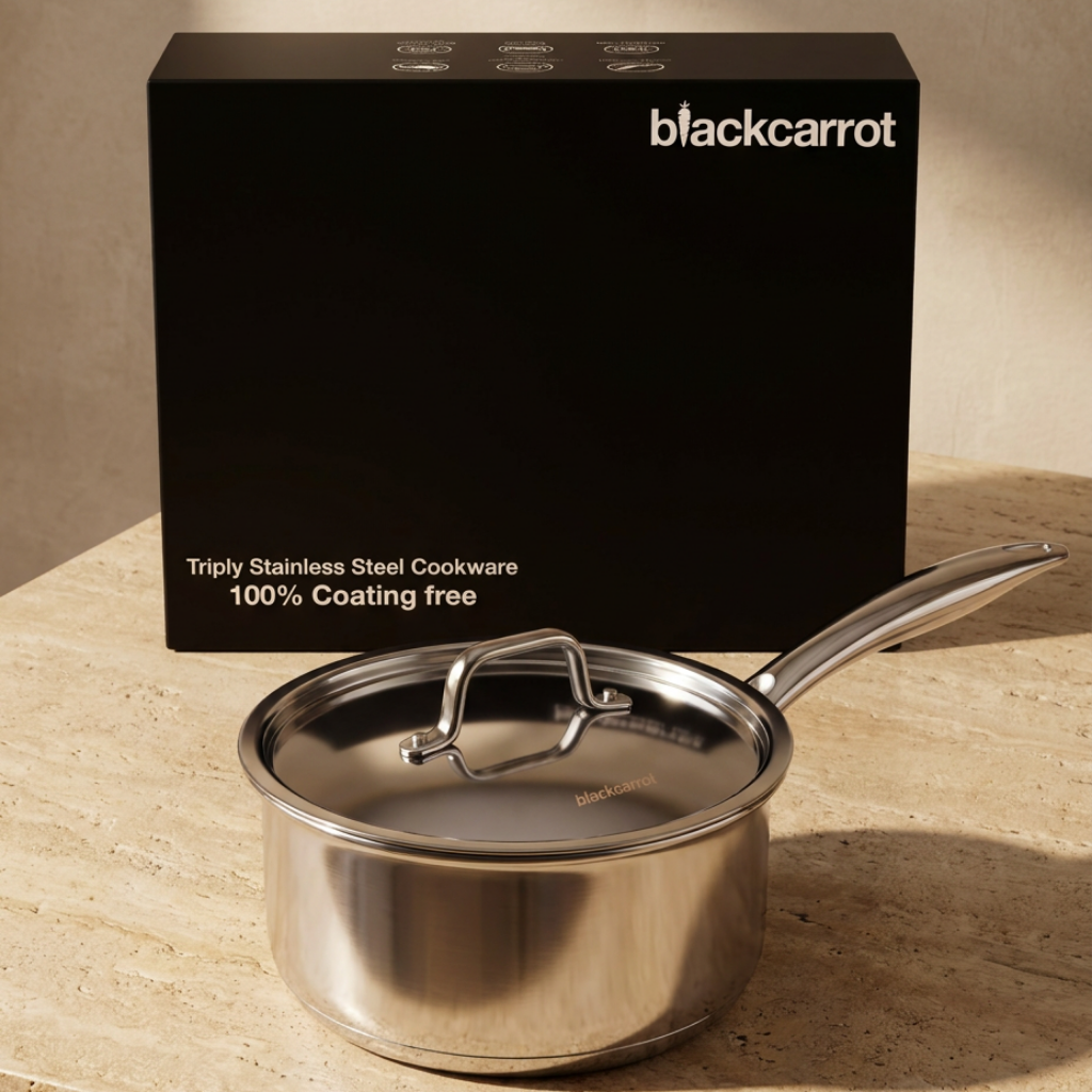 BlackCarrot triply stainless steel saucepan with lid placed beside its branded packaging box
