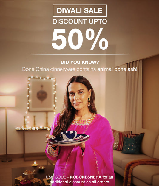 Premium Diwali gifts in India by BlackCarrot — bone-ash-free ceramic dinnerware, stainless-steel cutlery, and lead-free glassware arranged on a festive Diwali table with diyas and warm lighting.