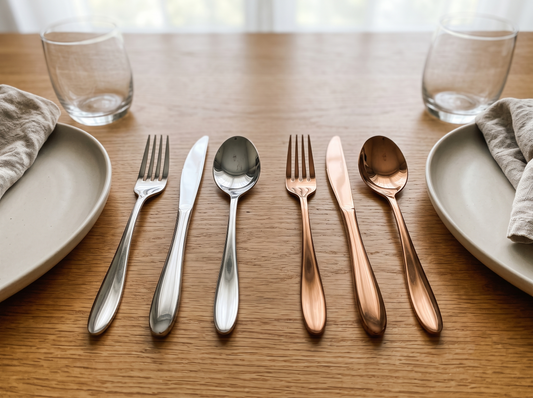 Black Carrot silver mirror finish and rose gold stainless steel cutlery sets arranged on a dining table