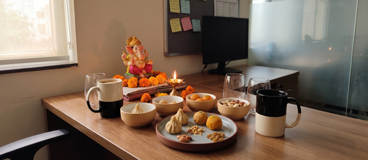 An office Ganesh Chaturthi prasad corner with Black Carrot small bowls, plates, mugs, and glasses