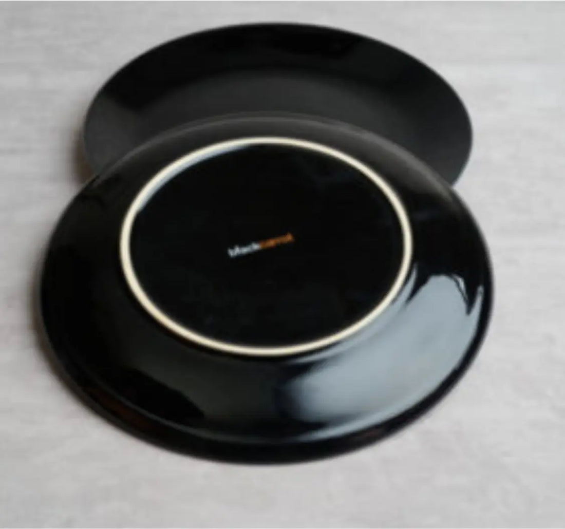  top and bottom view of sleek black ceramic dinner plates from BlackCarrot on a grey surface