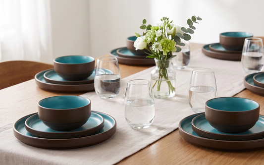Brown and turquoise ceramic dinner set with clear water glasses on an elegant dining table