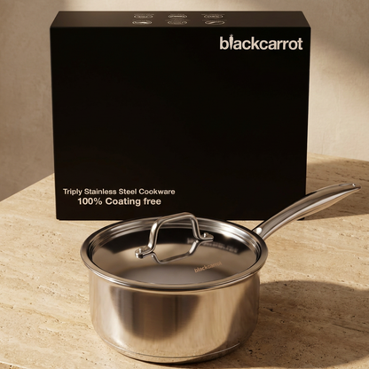 BlackCarrot triply stainless steel saucepan with lid placed beside its branded packaging box