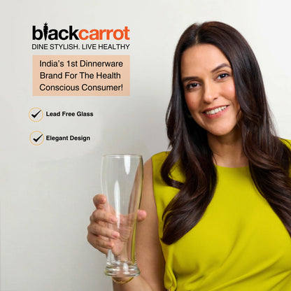 Woman holding a glass with BlackCarrot branding and product features on a light background